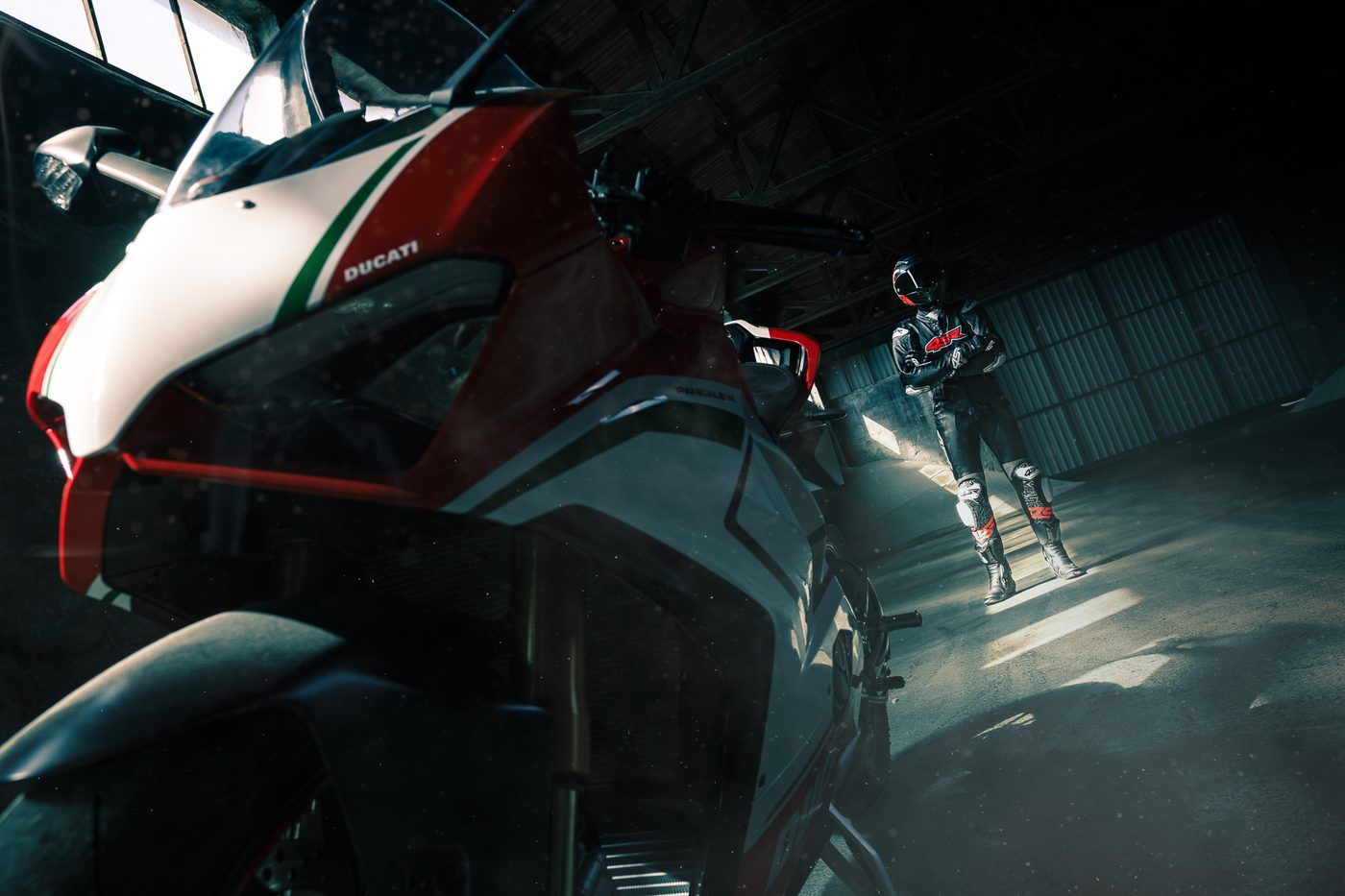Motorka Ducati a jezdec v kombinéze v hale