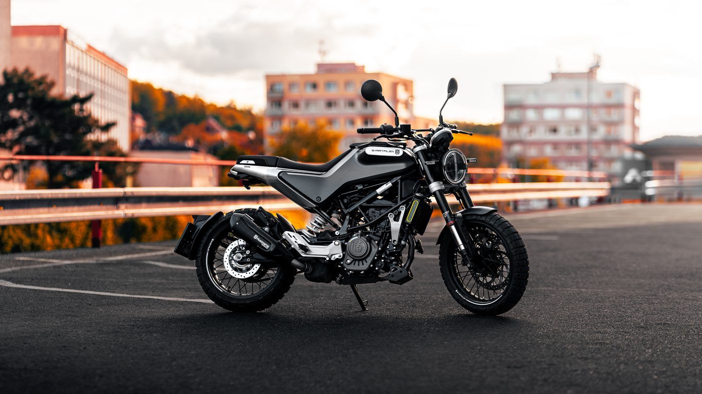 Motorka Husqvarna na parkovišti při západu slunce