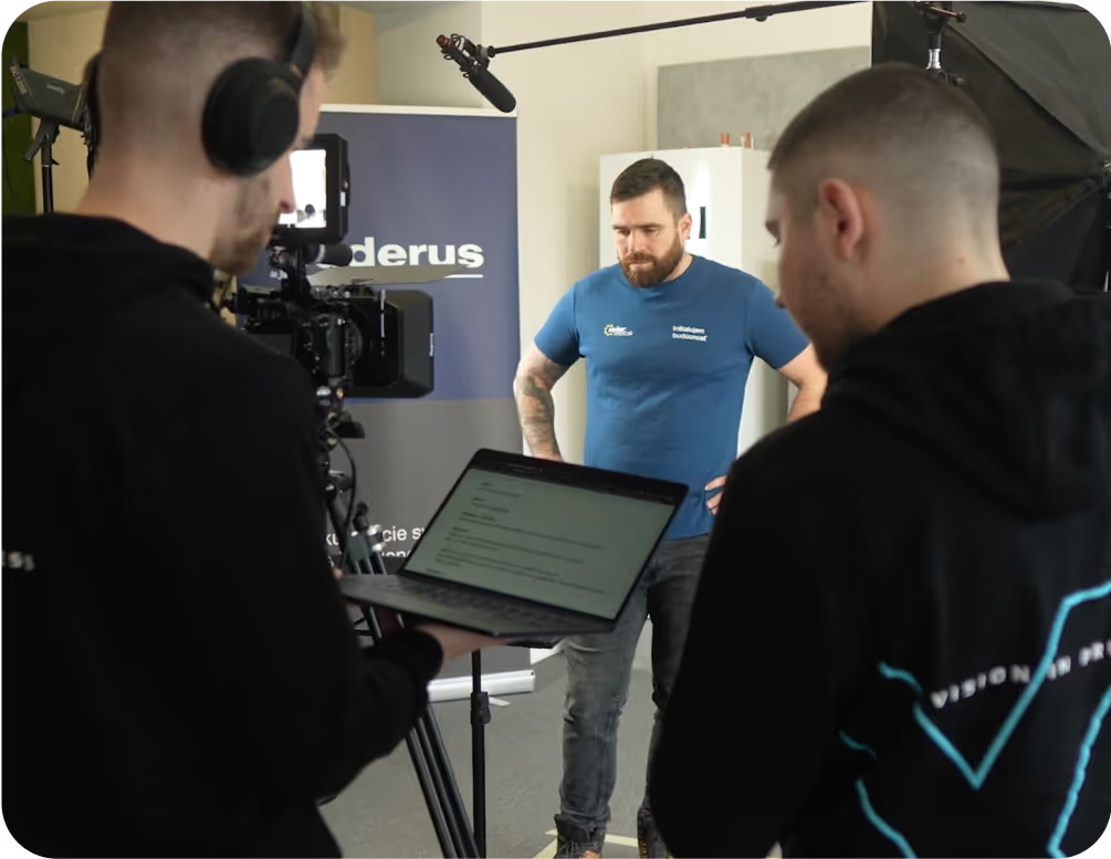 Natáčení videa v showroomu, kameraman a mluvčí v modrém tričku vedle tepelného čerpadla